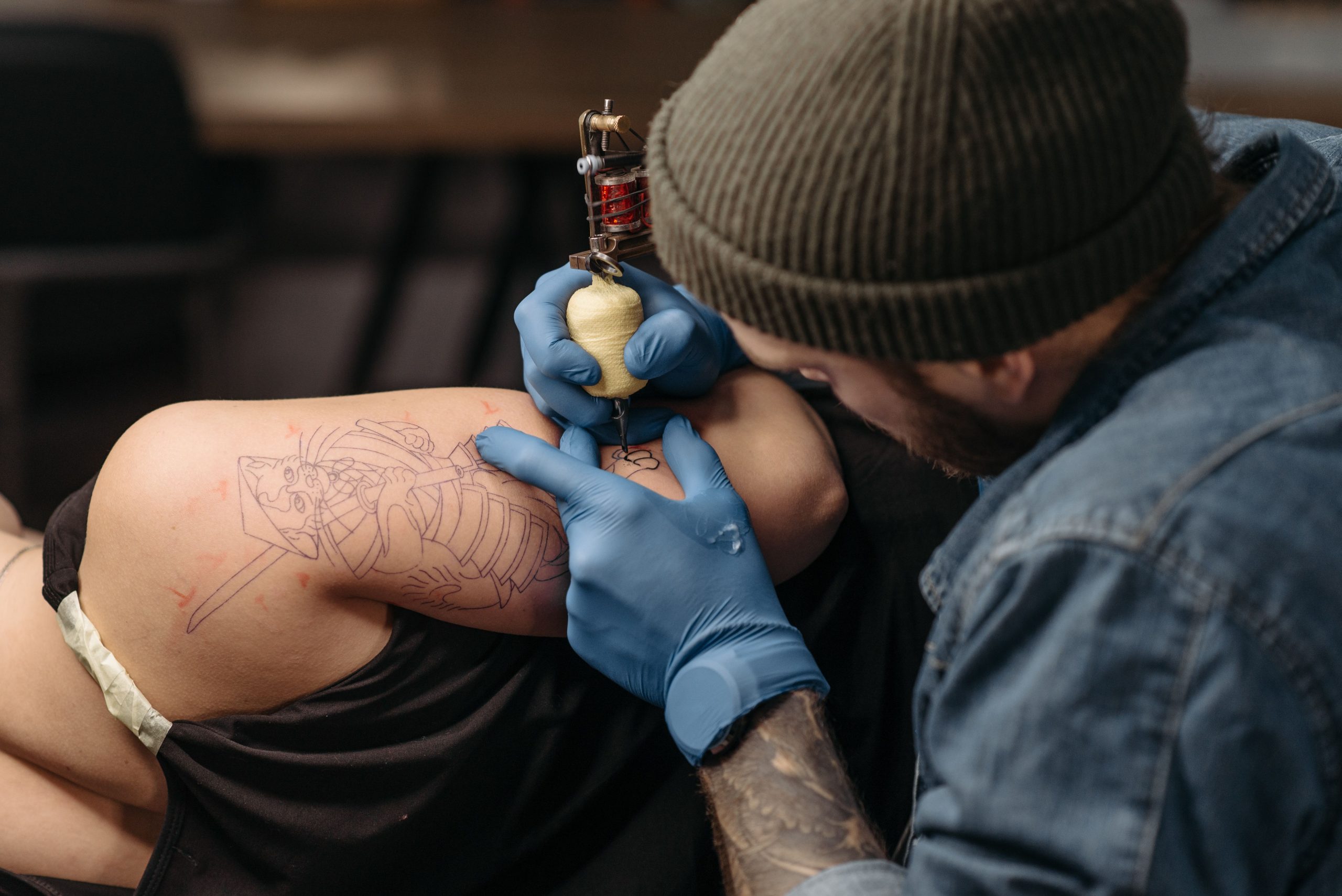 Tatoueur encrant un design complexe sur le bras d'un client