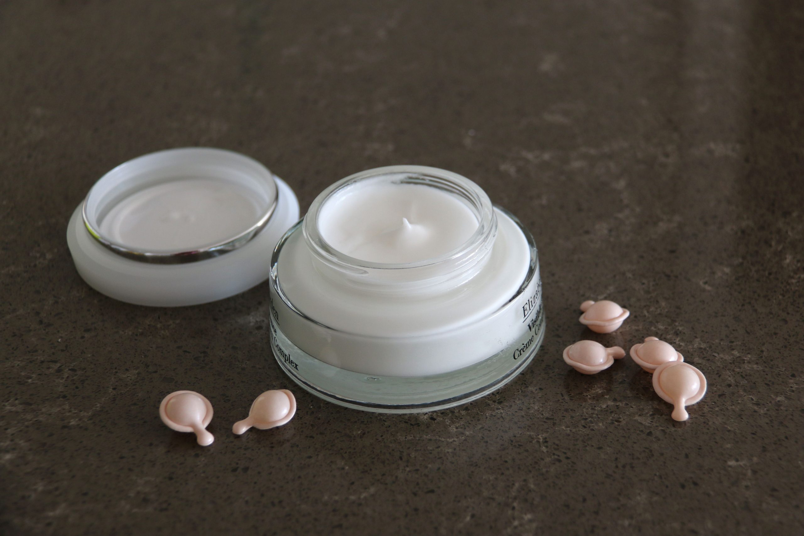 Pot ouvert de crème luxueuse avec capsules