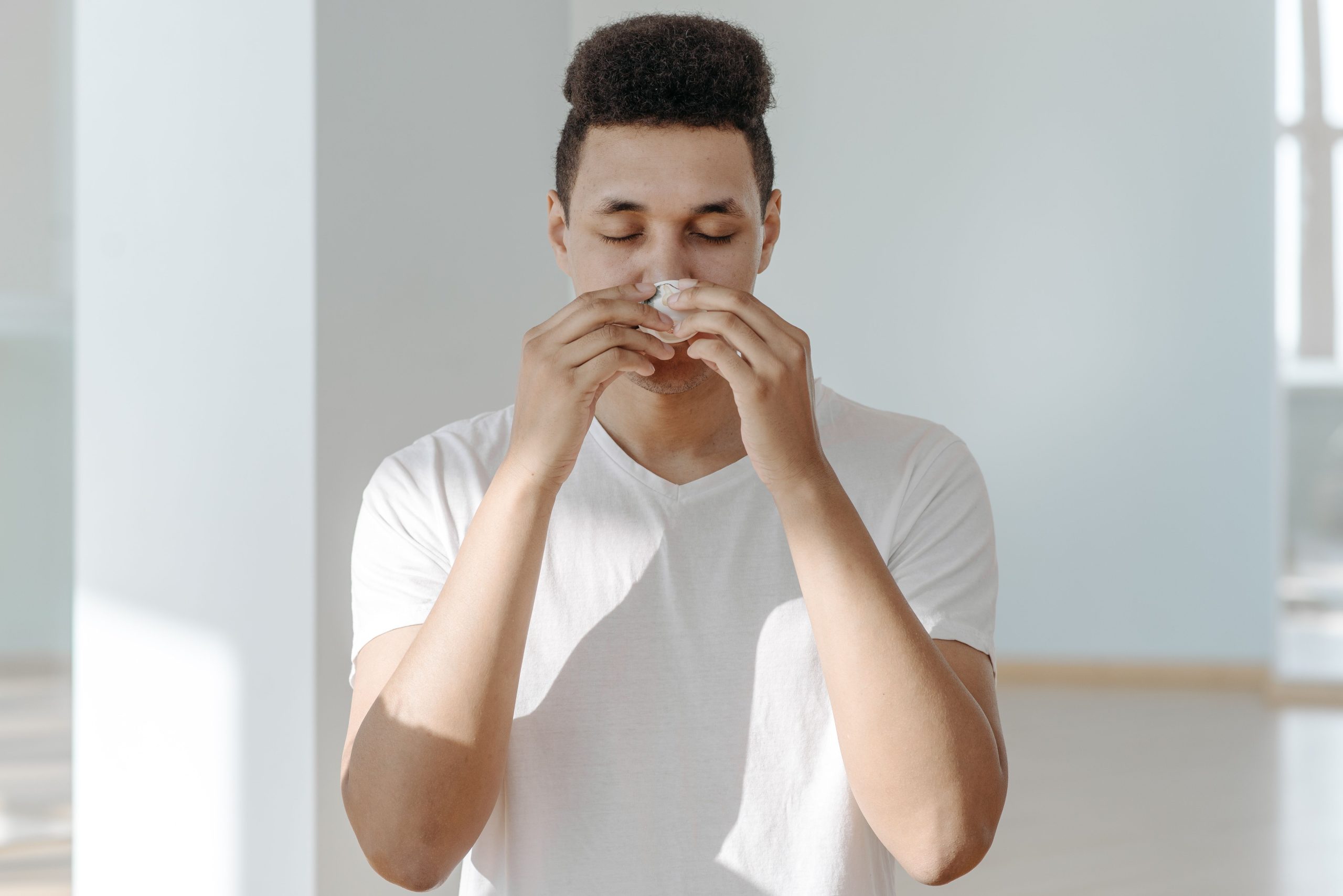 Homme éternuant dans un tissu blanc
