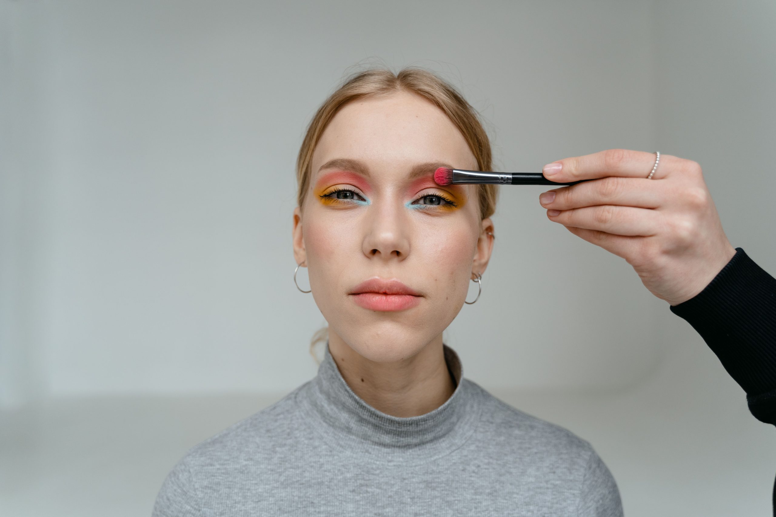 Femme avec fard à paupières vibrant appliqué au pinceau