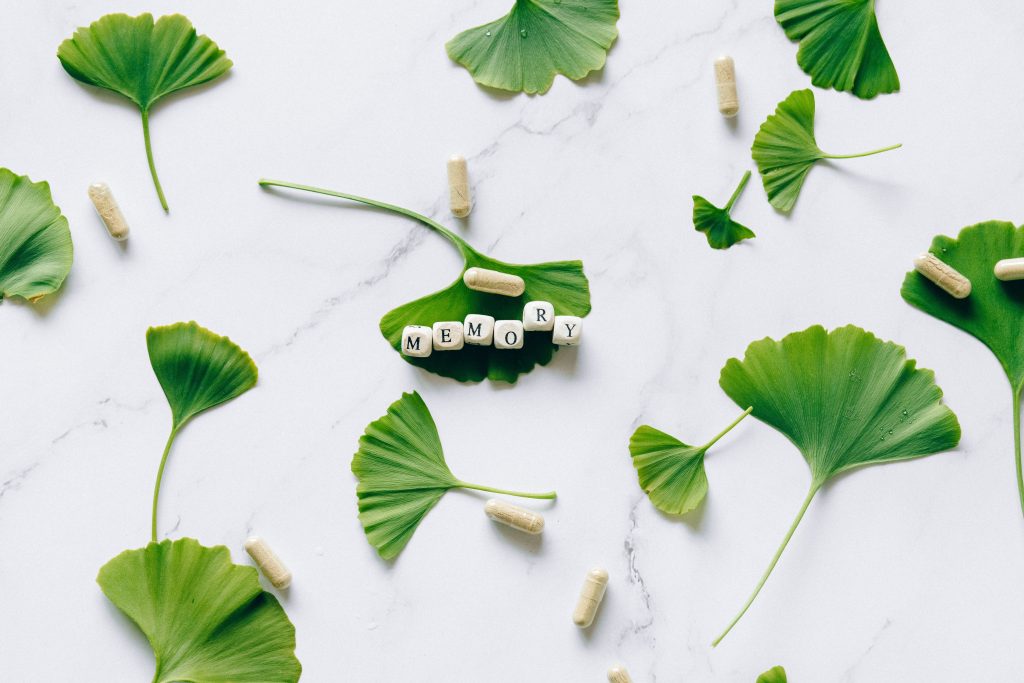 Feuilles ginkgo et capsules mémoire sur marbre