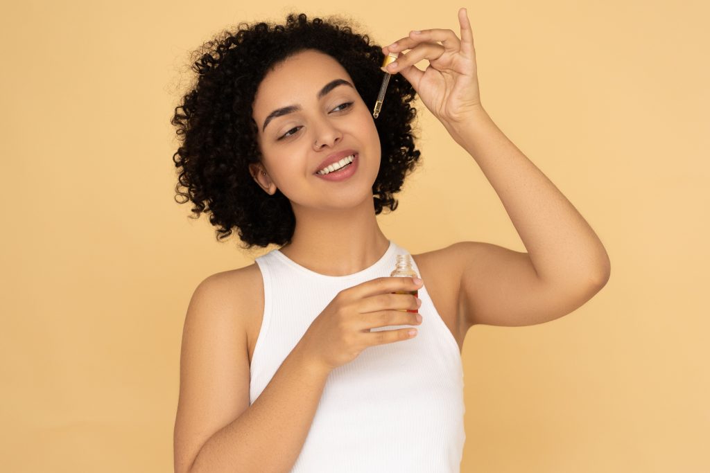 Femme appliquant huile carotte sur sa peau
