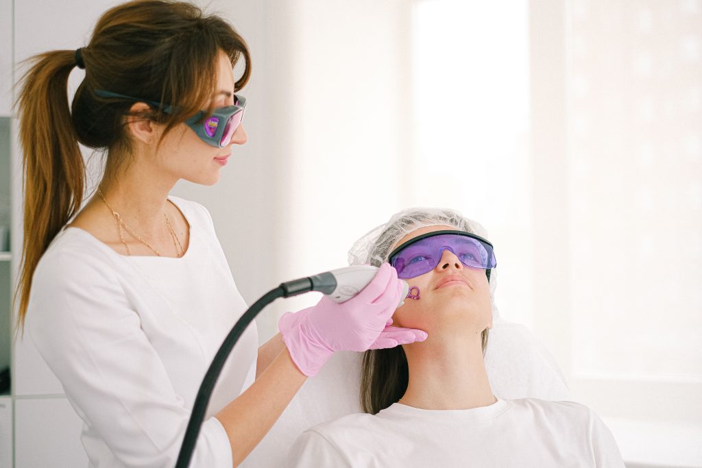 Cosmetologue appliquant un laser vbeam sur patiente