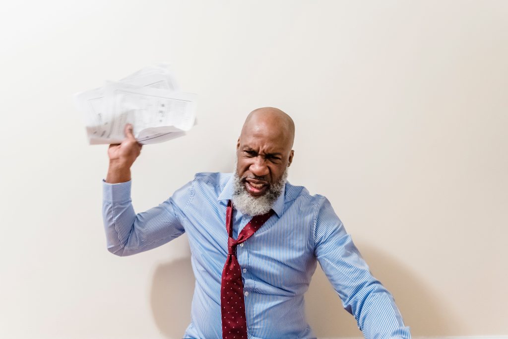 Homme frustré jetant des papiers avec colère
