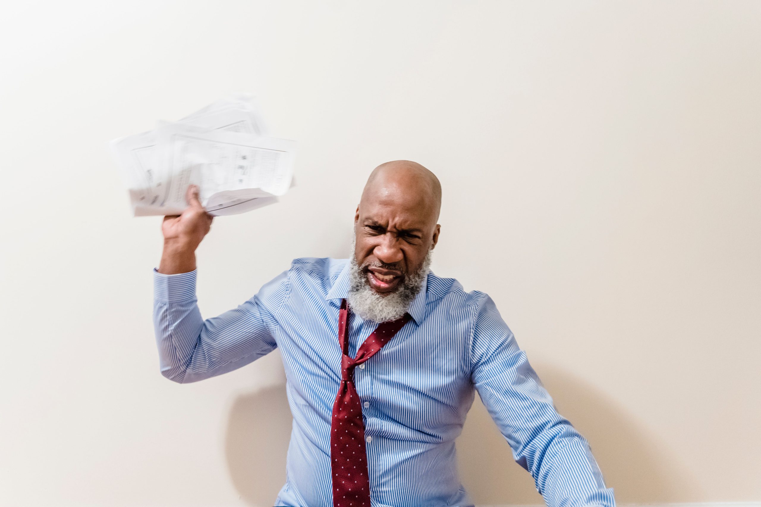 Homme frustré jetant des papiers avec colère