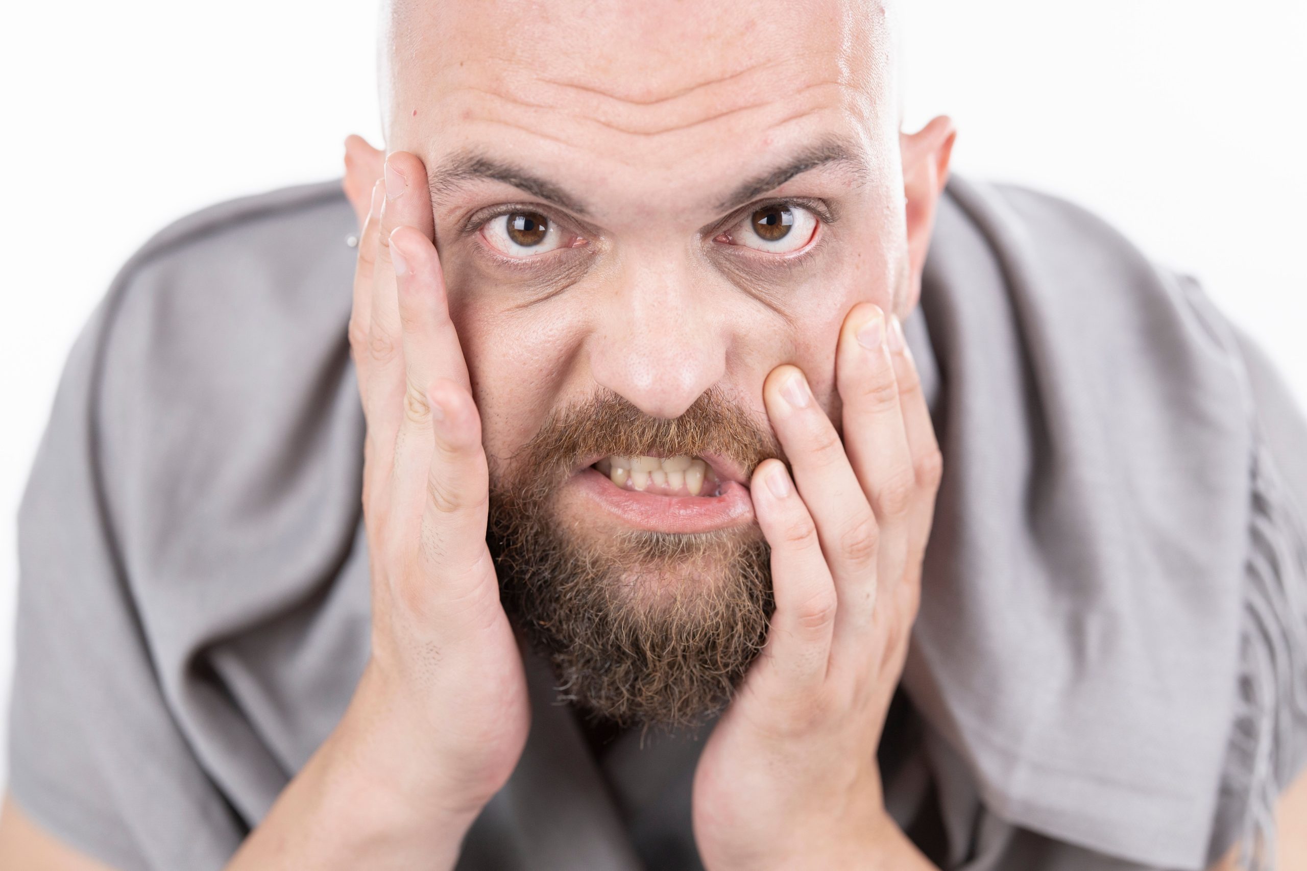 Homme barbu exprimant sa frustration intense
