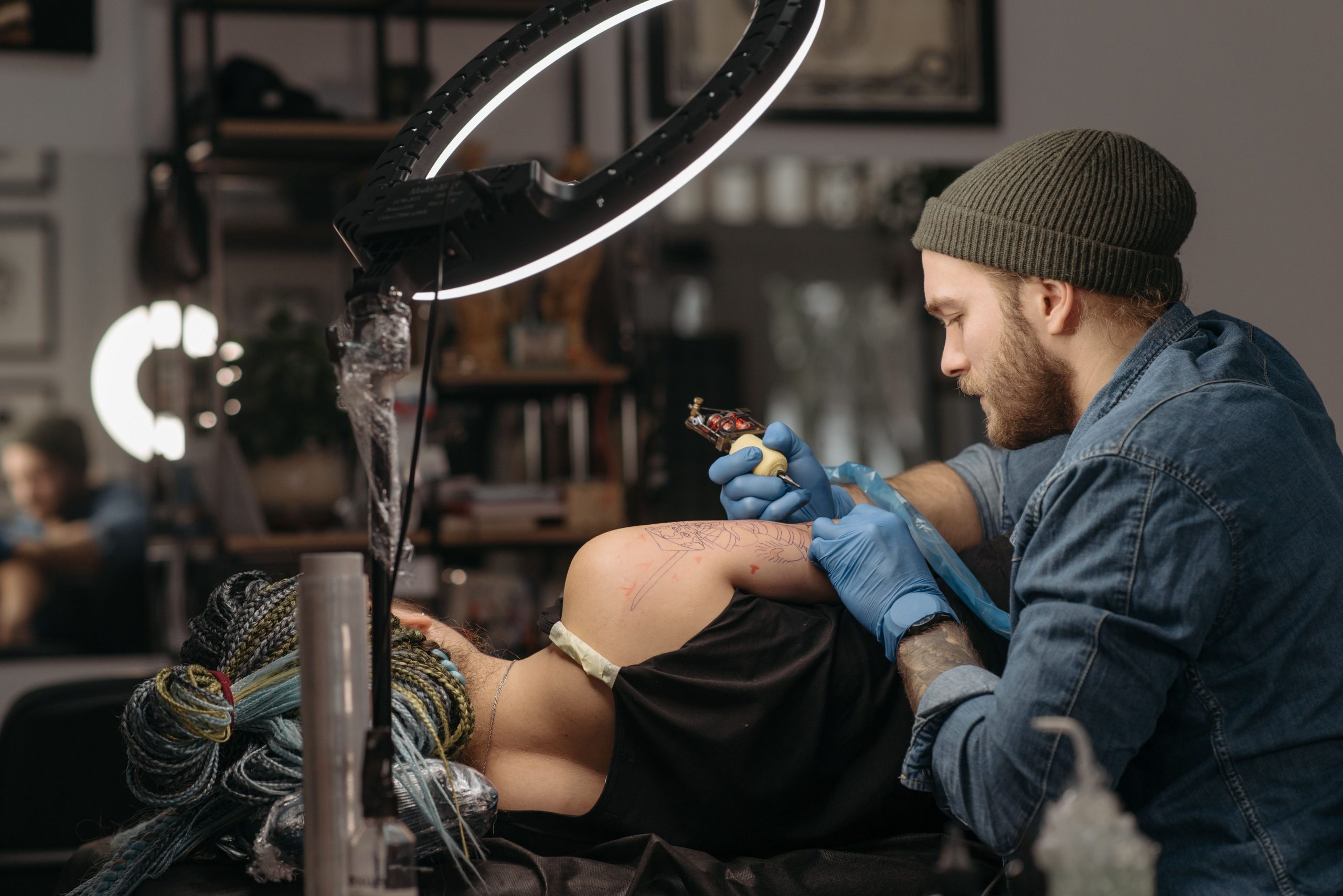 Tatoueur travaillant sur le bras d'un client en studio moderne