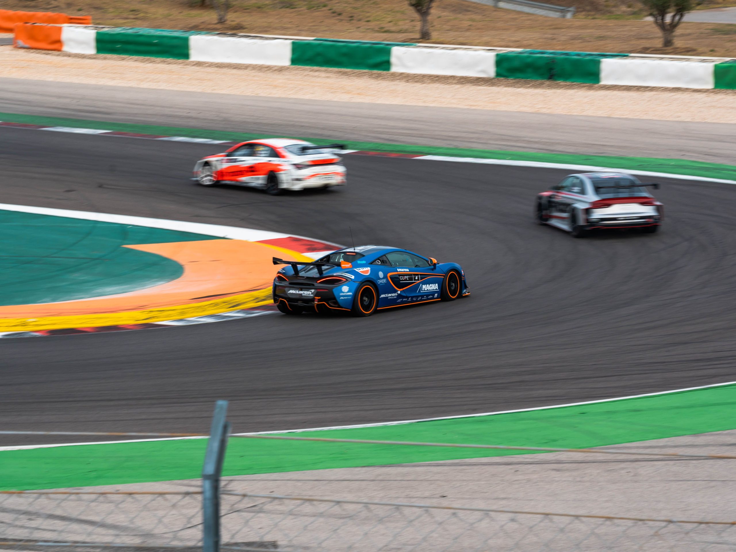 Voitures de course accélérant sur piste courbe