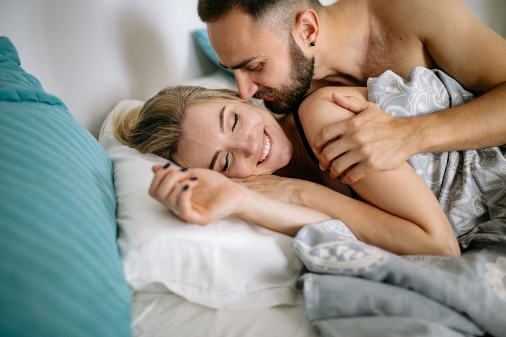 Couple heureux s'embrassant au lit avec affection