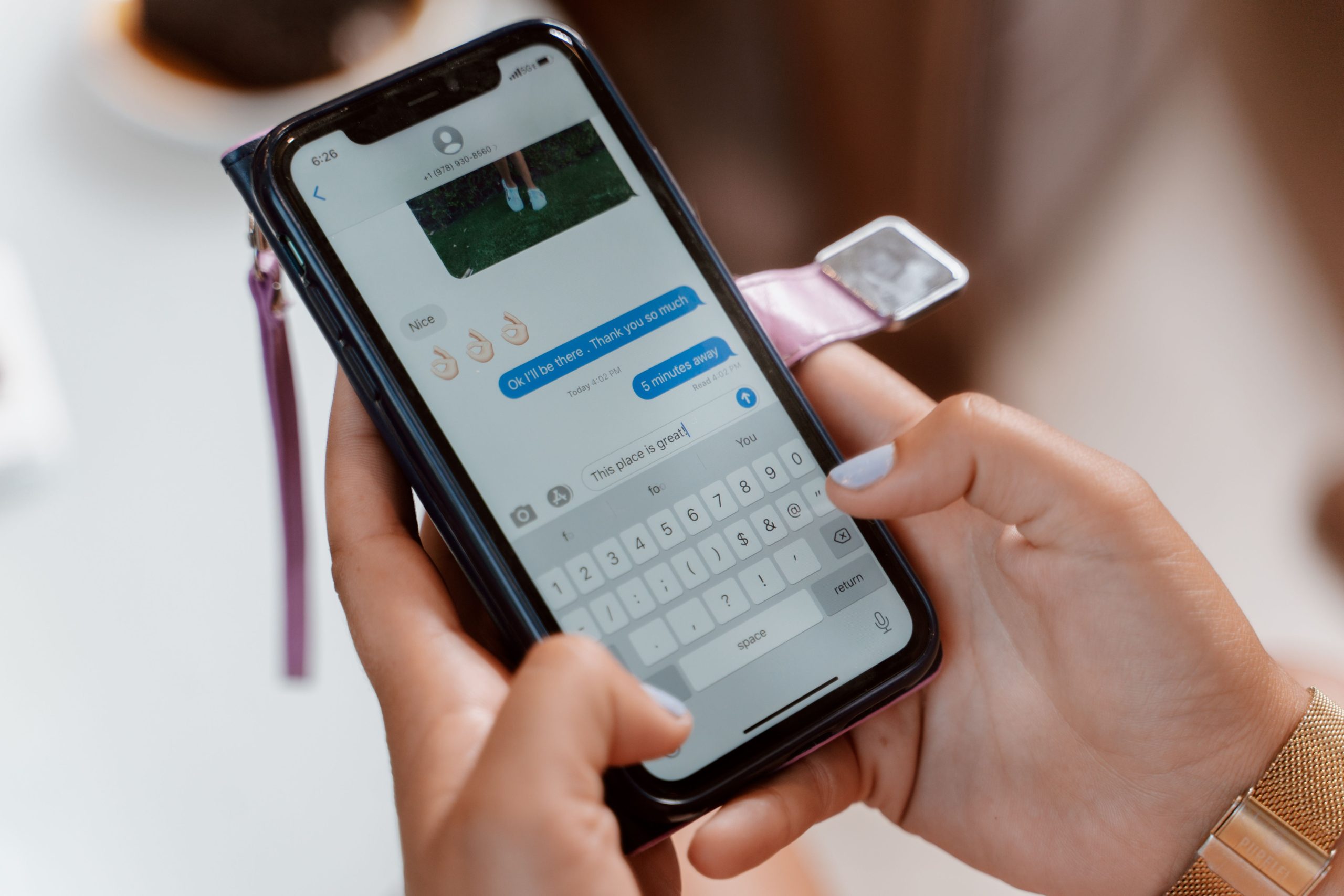 Femme envoyant un message texte avec emojis sur téléphone