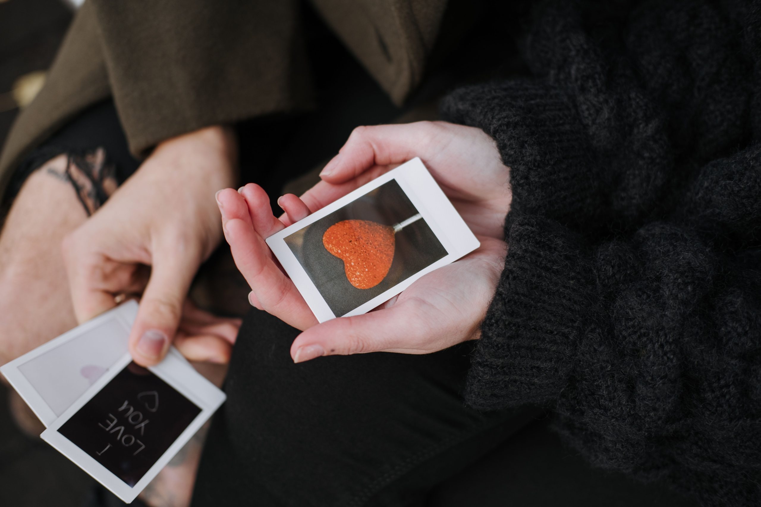 Couple en tenue chaude avec photos et bonbons coeur
